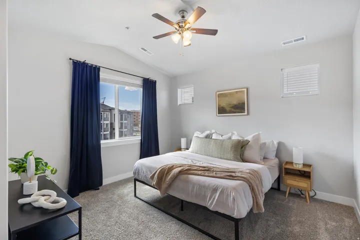 Bedroom featuring a vaulted ceiling and a ceiling fan with integrated lighting