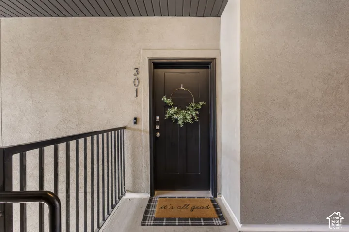 Entryway featuring a dark paneled door with modern hardware, textured wall finish, and dark slat ceiling