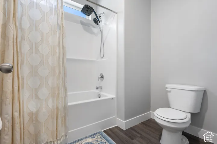 Tub and shower combination featuring a contemporary showerhead, chrome fixtures, and white acrylic surround