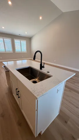 Kitchen island featuring a stainless steel undermount sink and a matte black faucet