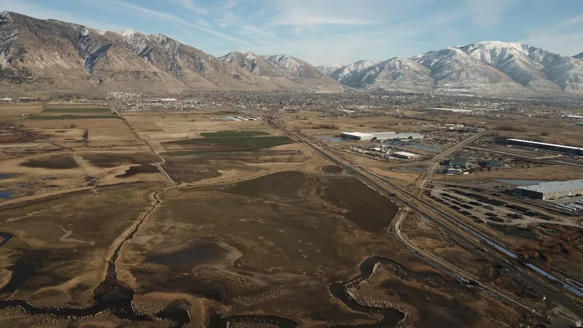 Expansive land featuring natural waterways and distant snow-capped mountains