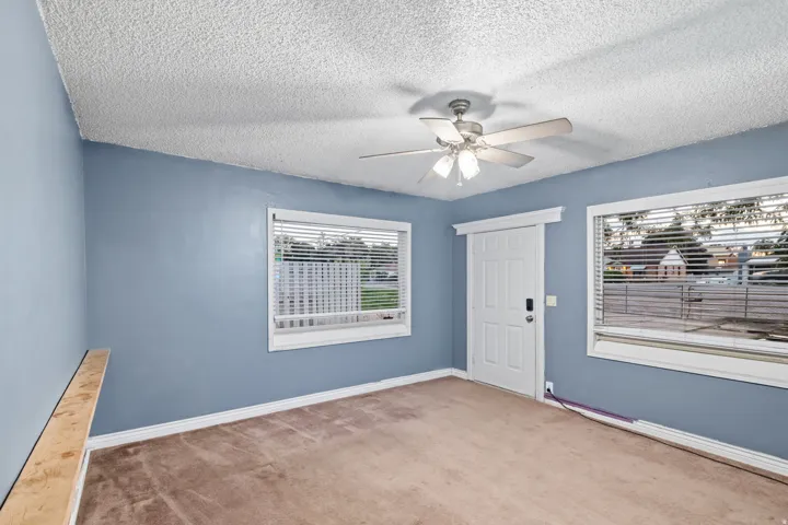 Room featuring light blue walls, a textured ceiling, and neutral-toned carpeting