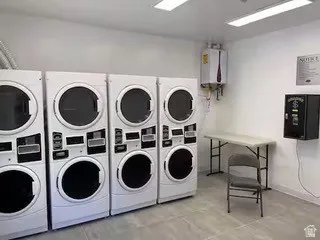 Dedicated laundry area featuring multiple commercial-grade washer and dryer units
