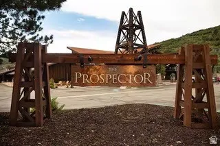 "The Prospector" sign crafted from wood-finish materials and weathered metal, featuring a decorative mining derrick structure