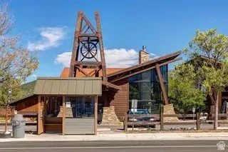 Distinctive architectural facade featuring a prominent mining-themed tower, expansive window walls, natural wood siding, stone accents, and an angular roofline