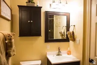 Bathroom vanity featuring a single basin sink, chrome faucet, and a dark wood-finish cabinet