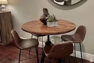Wood-finish flooring paired with light-toned wall paint and an accent mirror