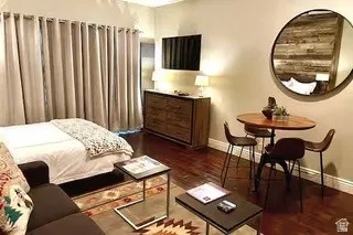 Compact living area featuring wood-finish flooring, light-toned walls, and recessed lighting