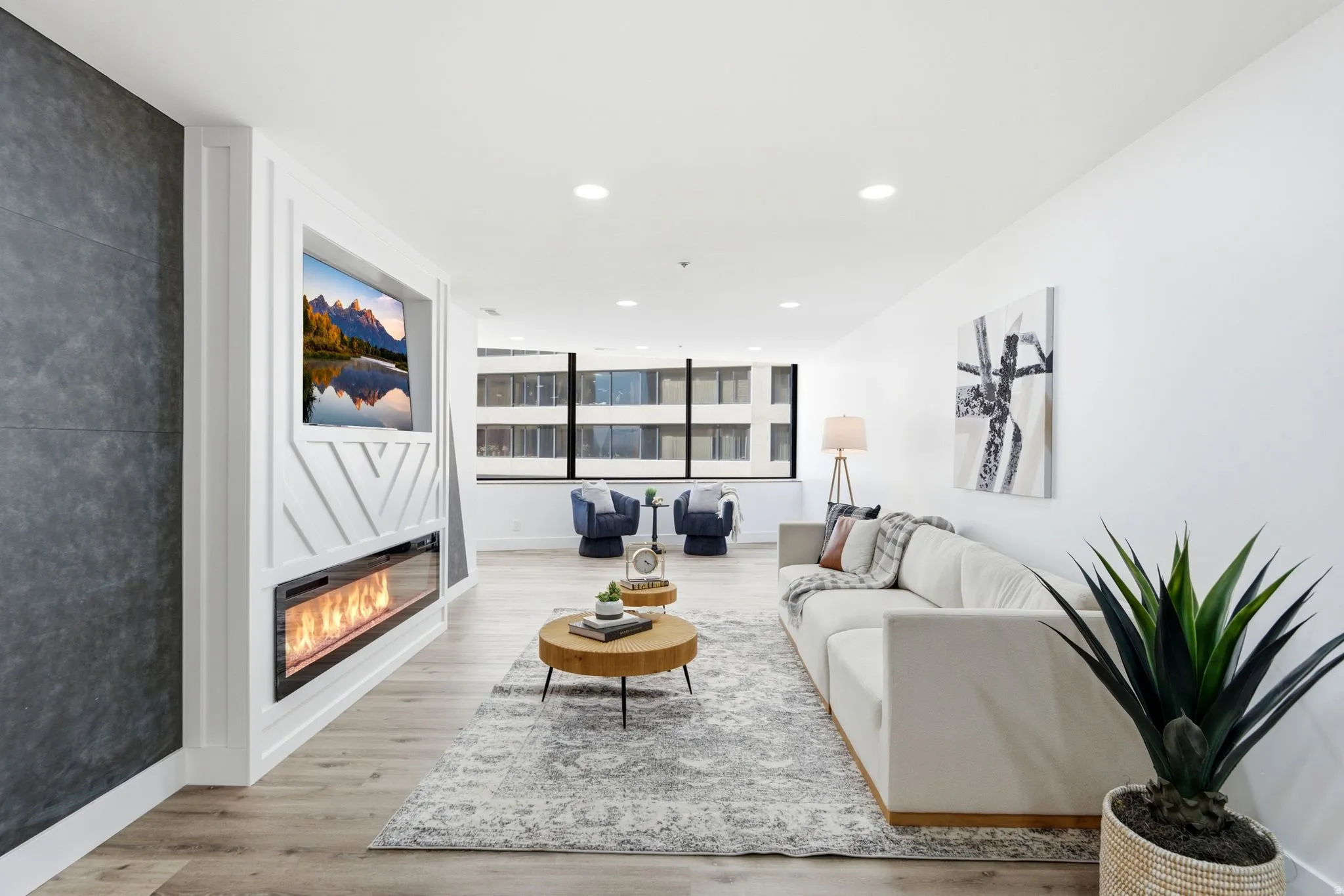 Living space featuring a built-in media wall with an electric fireplace, recessed lighting, and light wood-finish flooring