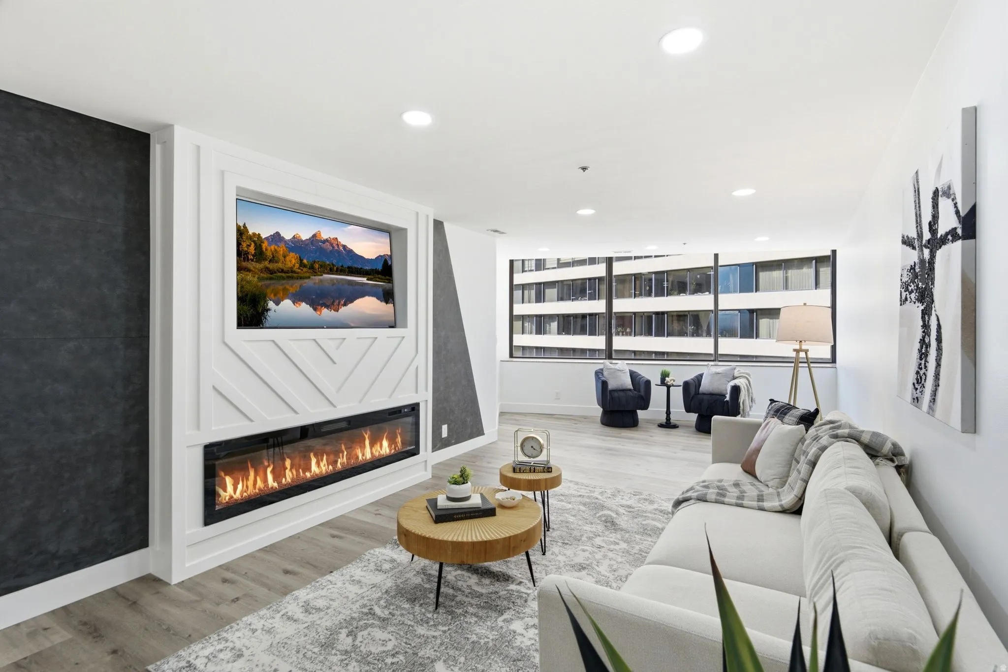 Living area featuring a white accent wall with geometric paneling and a built-in linear fireplace