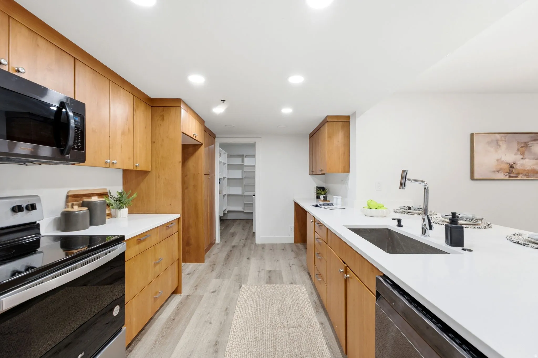 Modern kitchen featuring wood cabinetry, white countertops, built-in appliances, recessed lighting, and wood-finish flooring
