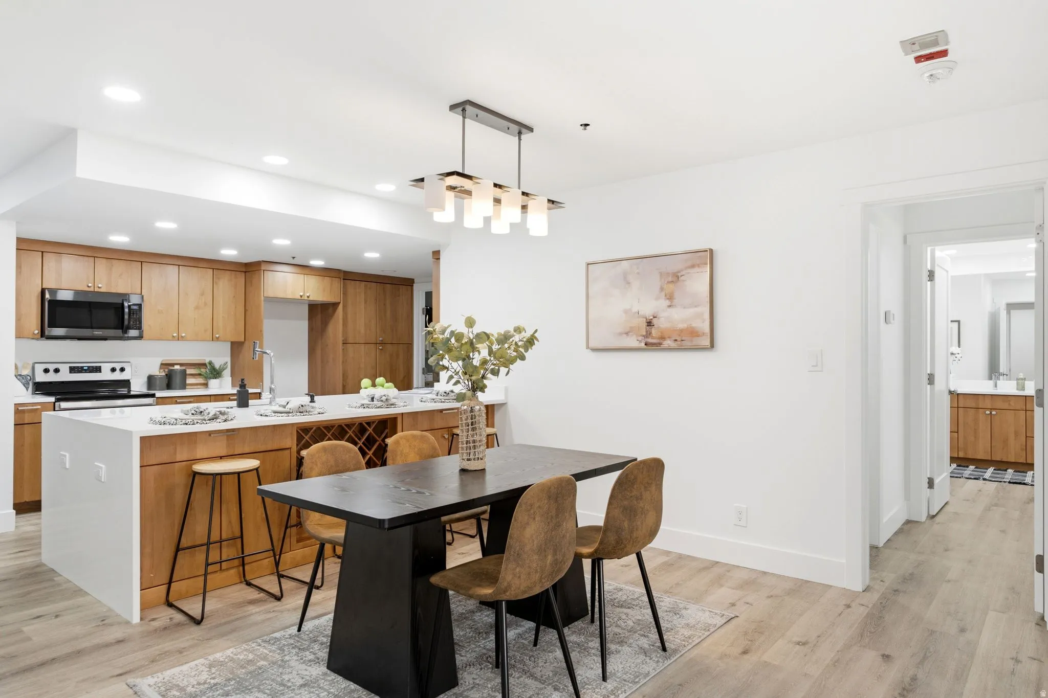 Open-concept kitchen and dining area featuring light wood-finish flooring