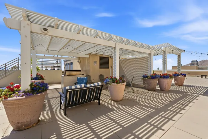 Rooftop patio with an expansive white pergola and string lighting