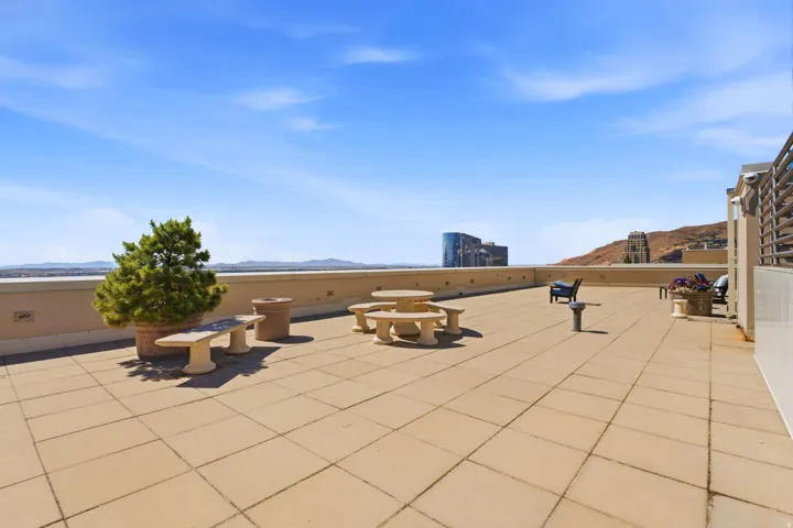 Expansive rooftop terrace featuring large format tile flooring, a low perimeter wall, and distant mountain scenery