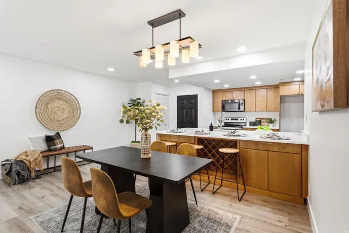 Open-concept dining area featuring wood-finish flooring and a contemporary chandelier