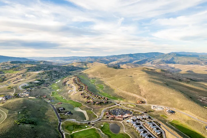 Expansive mountain landscape featuring residential developments, golf courses, and roadways