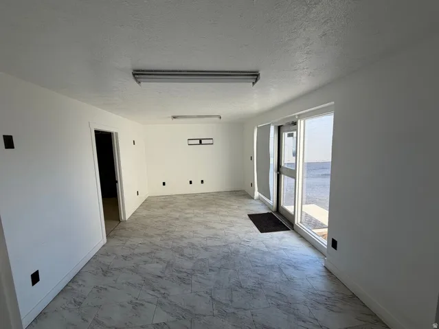 Spacious interior room with light-toned tile flooring and white painted walls