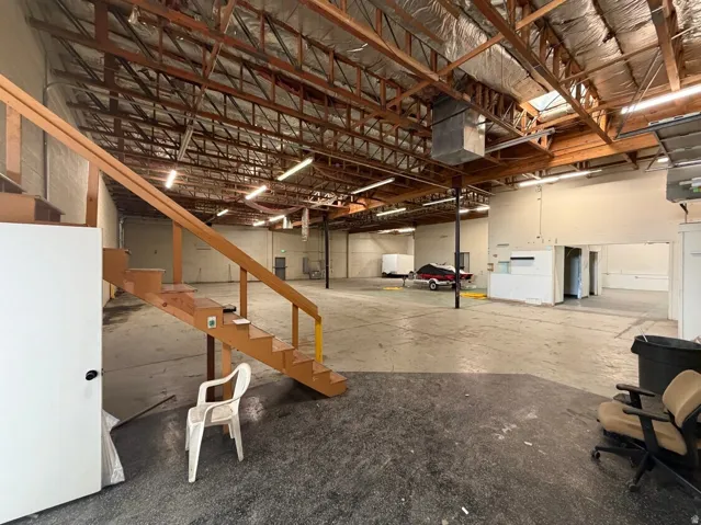 Spacious industrial interior featuring exposed wood beam ceilings and concrete flooring
