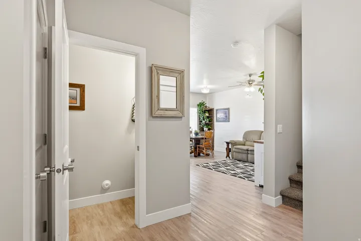 Interior hallway featuring wood-finish flooring, white trim, and light gray wall paint