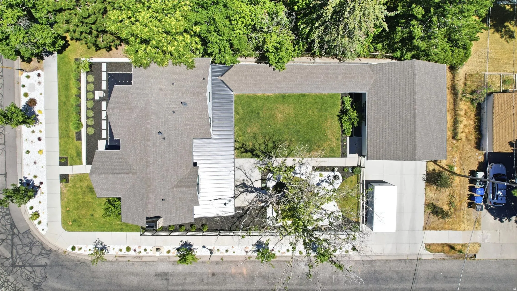 Expansive corner lot featuring a multi-pitched roofline and a combination of shingle and standing seam metal roofing