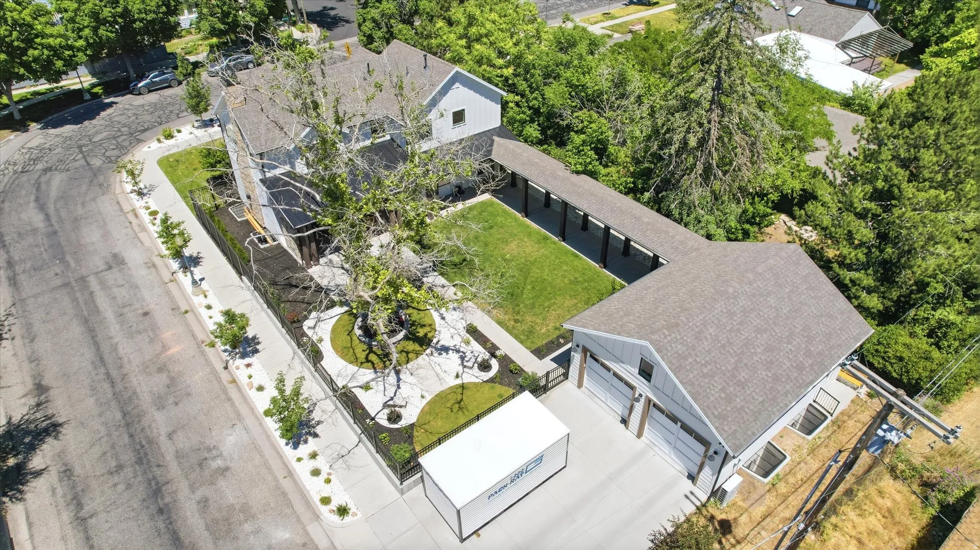 Aerial property overview featuring a two-story residence with a detached three-car garage