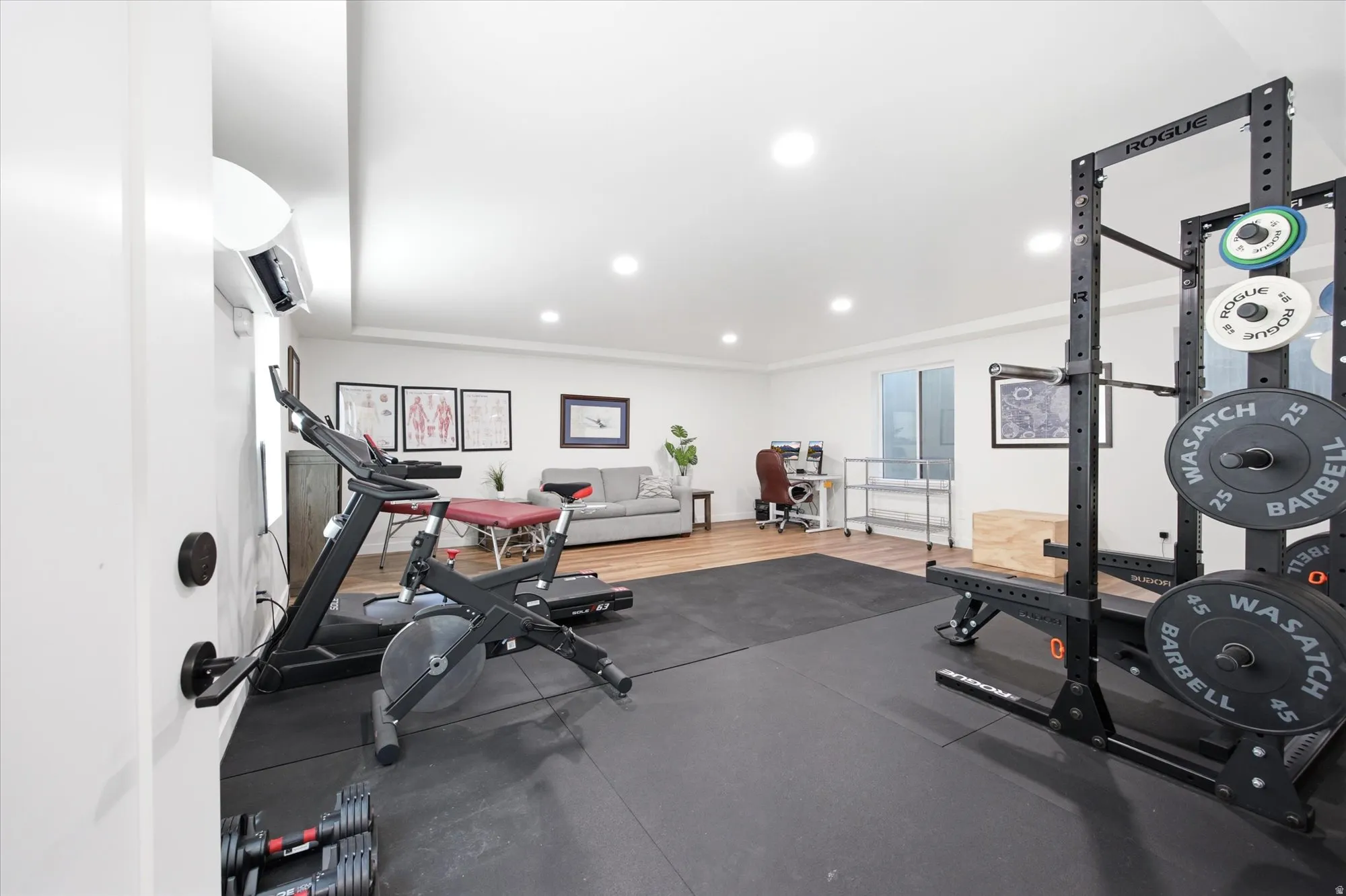 Basement home gym/flex space featuring dedicated fitness flooring, recessed lighting, wood-finish flooring, and a large window