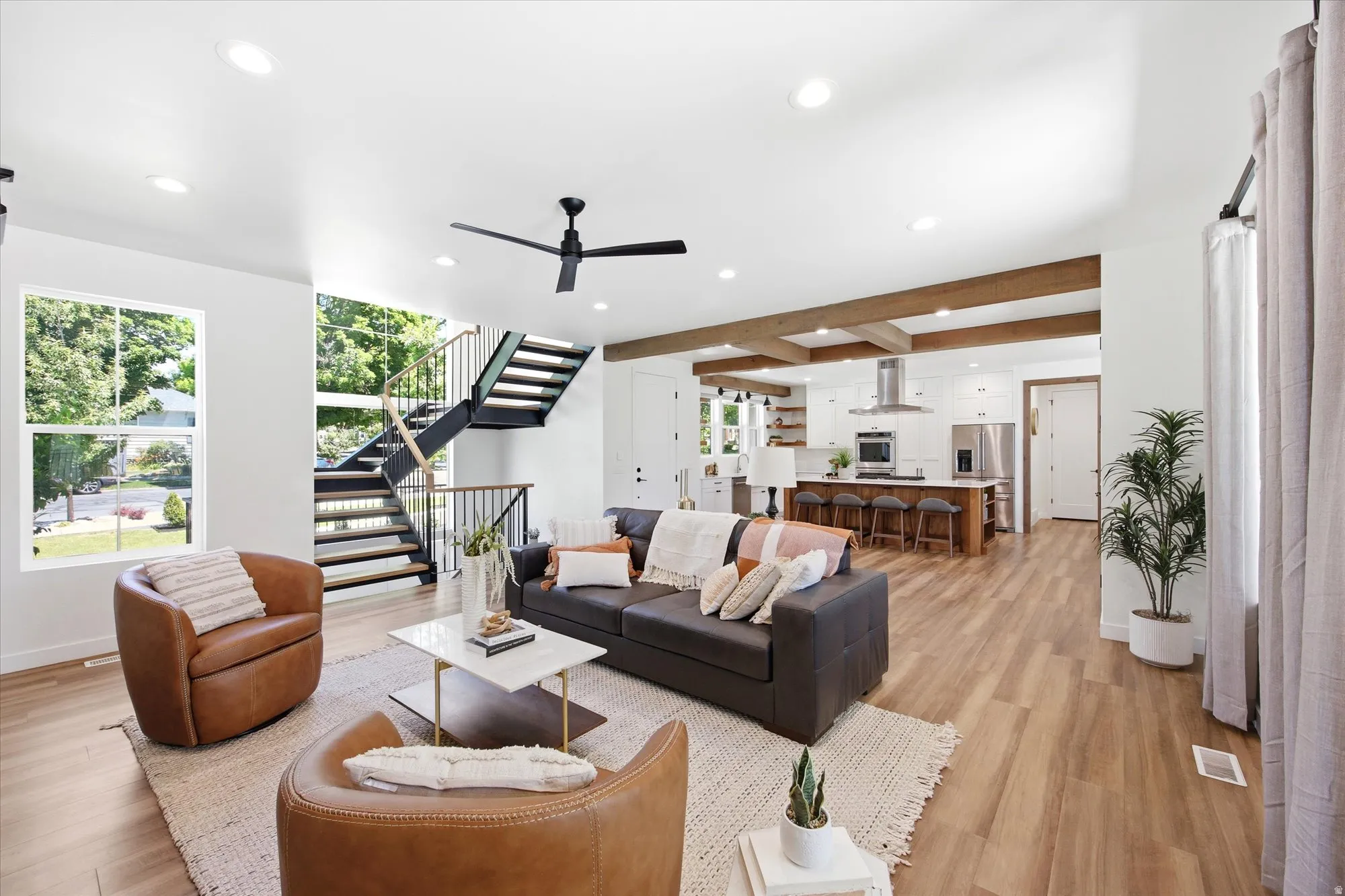 Open-concept living space featuring wood-finish flooring, recessed lighting, and a modern ceiling fan