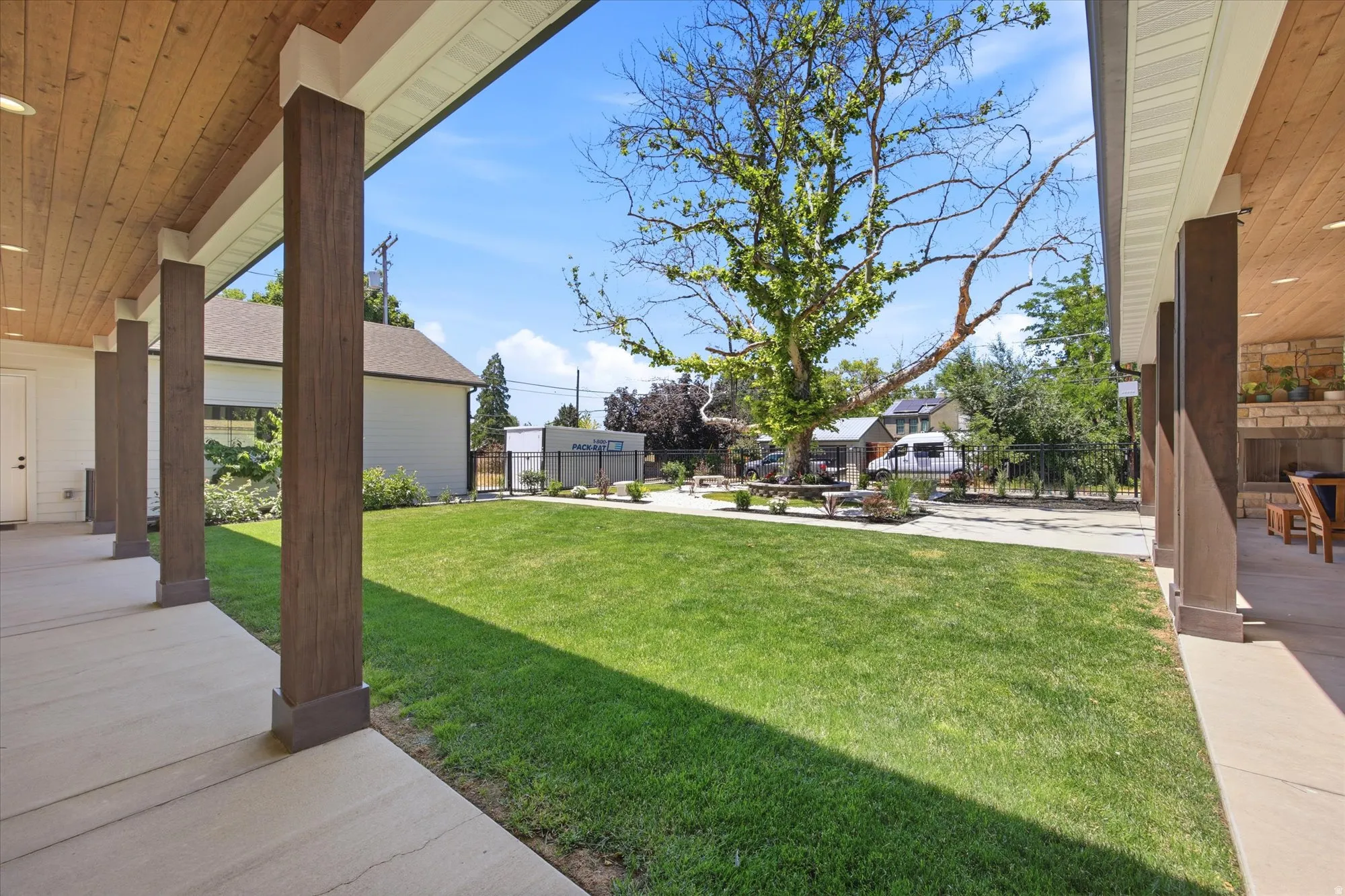 Covered patio with a wood-finish ceiling and recessed lighting, concrete flooring, and substantial support columns