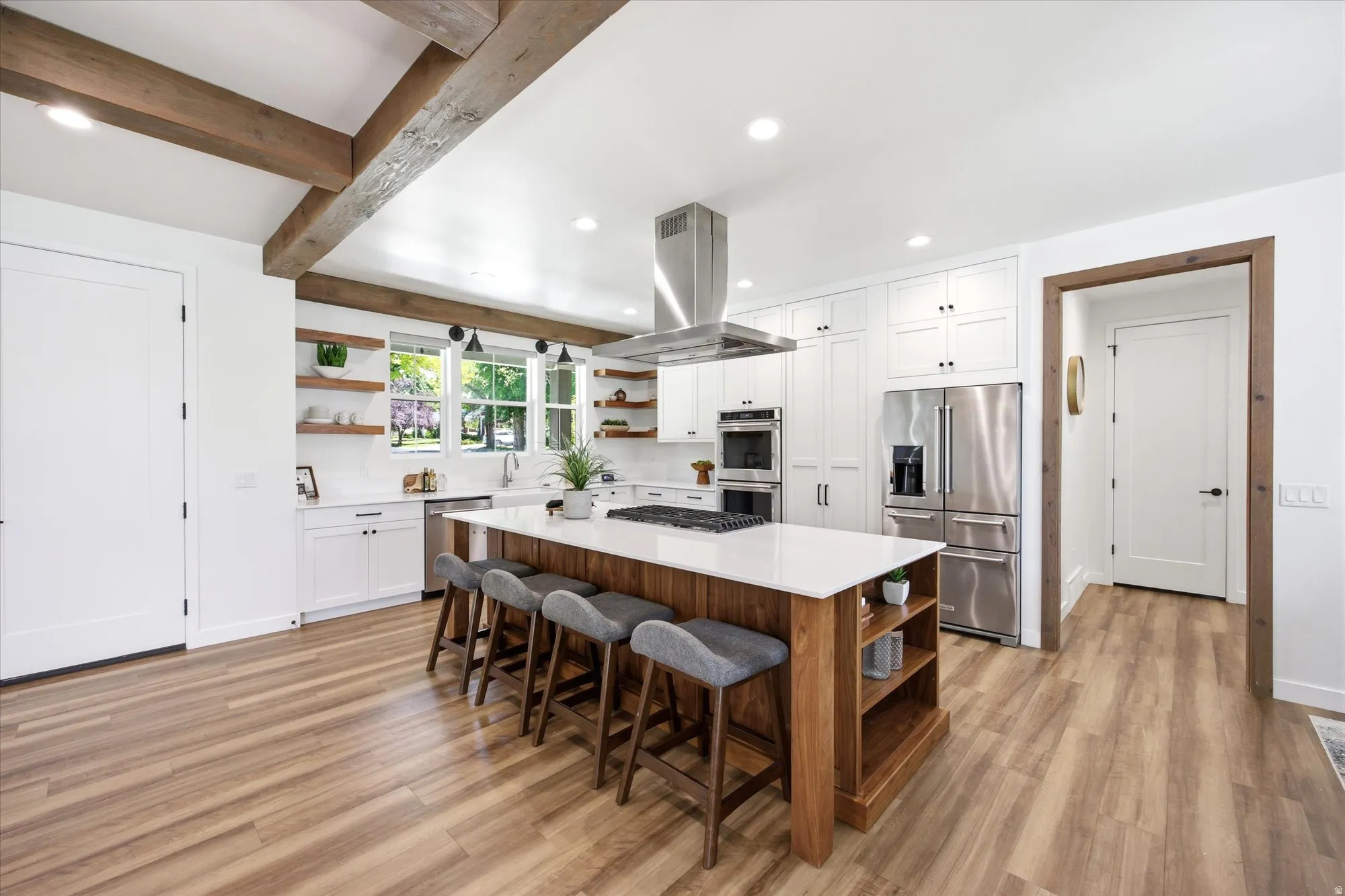 Spacious kitchen featuring wood-finish flooring and exposed beam ceiling