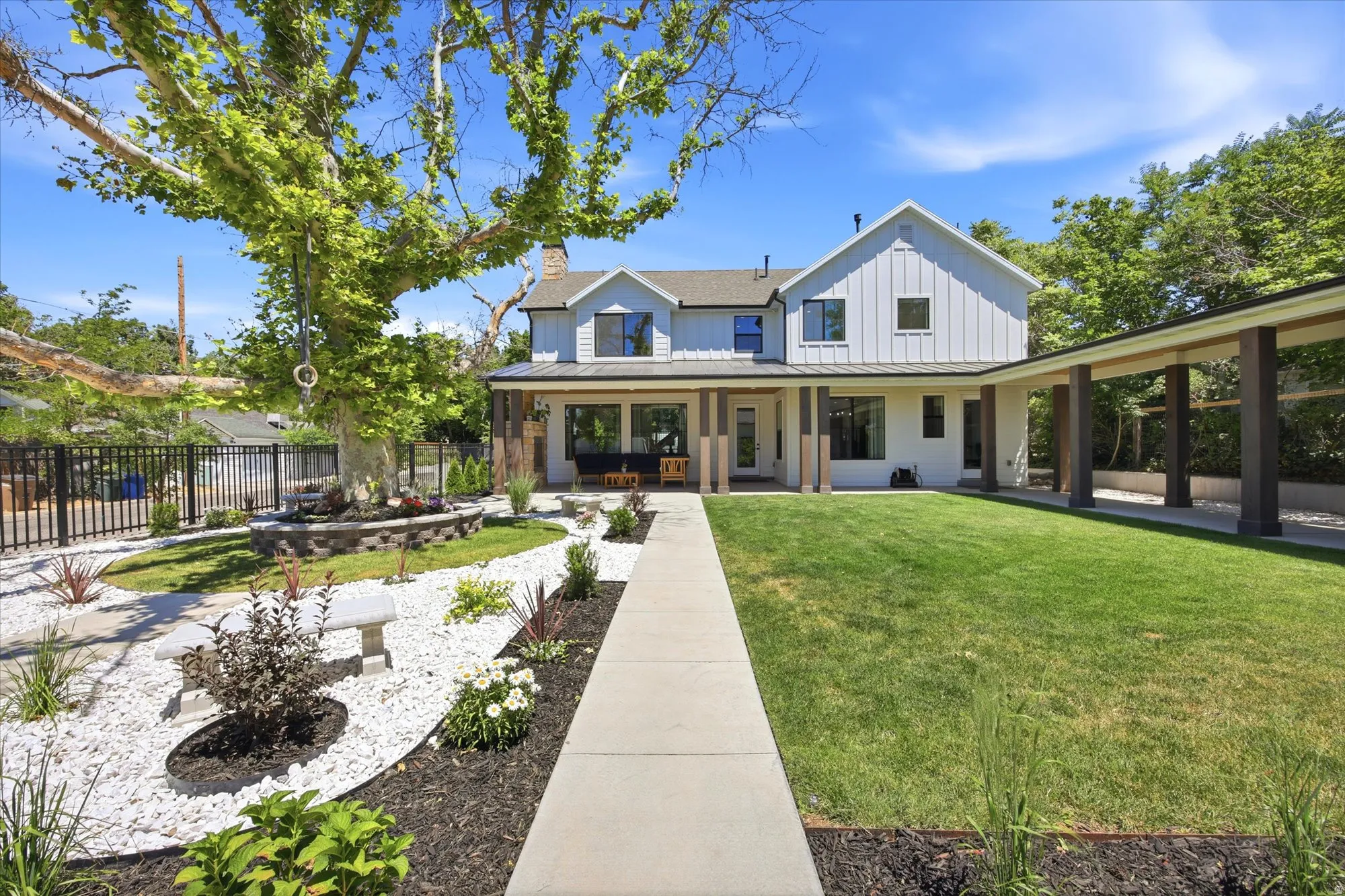 Contemporary home with board and batten siding, a covered porch, and an attached covered walkway