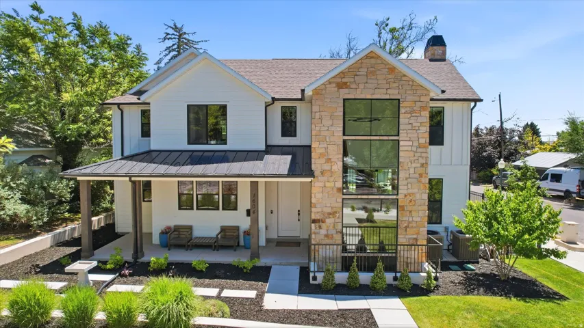 Modern farmhouse exterior with board and batten siding, stone facade, and a metal roof accent