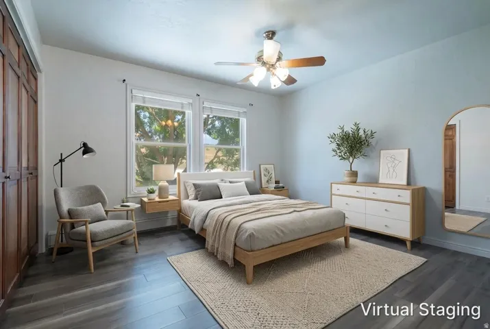 Spacious room featuring wood-finish flooring, light blue wall paint, and a ceiling fan with light fixture