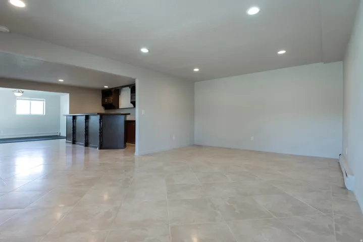 Spacious interior featuring large format tile flooring, recessed lighting, and a neutral color palette