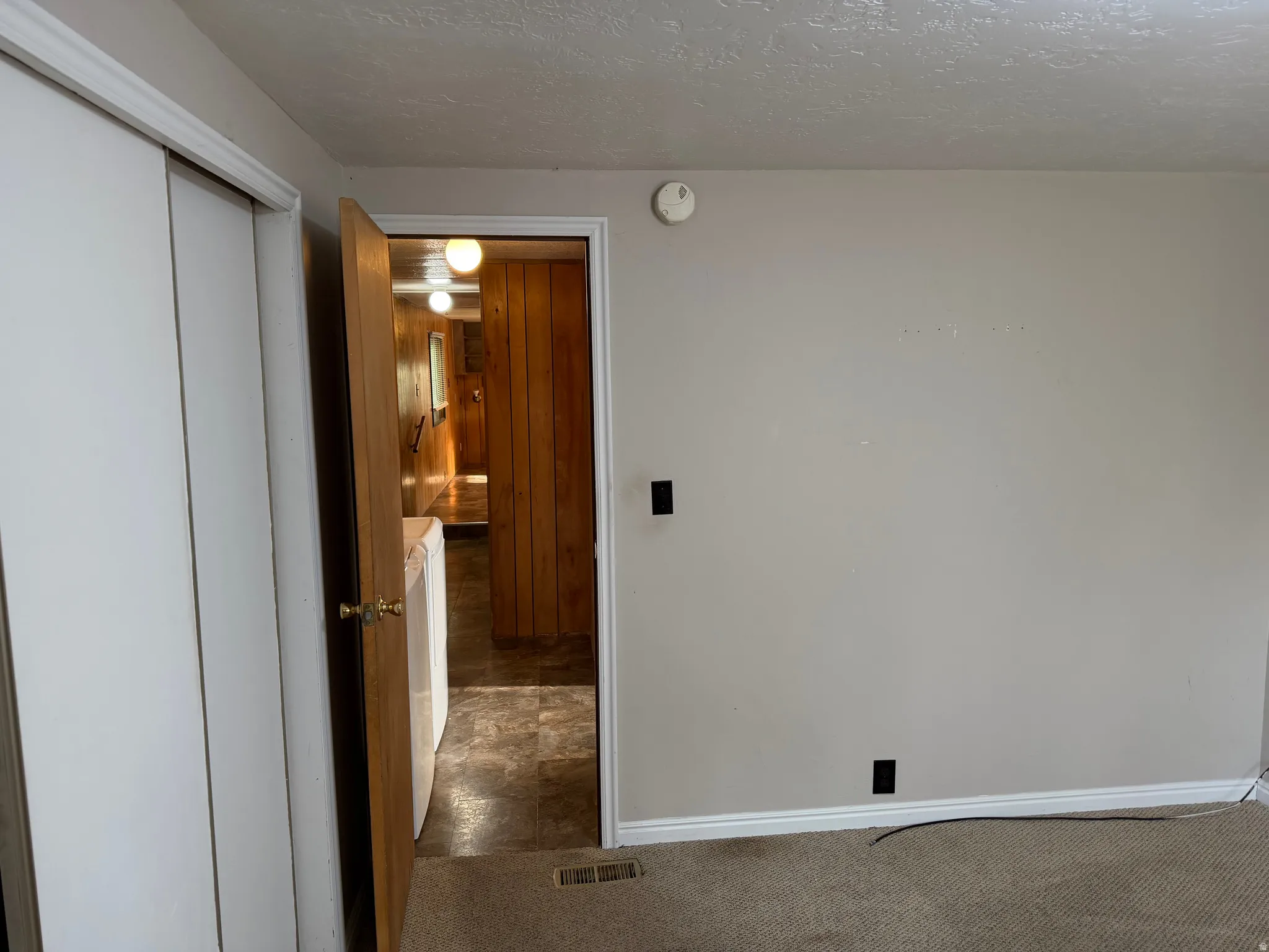 Room featuring neutral painted walls, textured ceiling, and carpet flooring