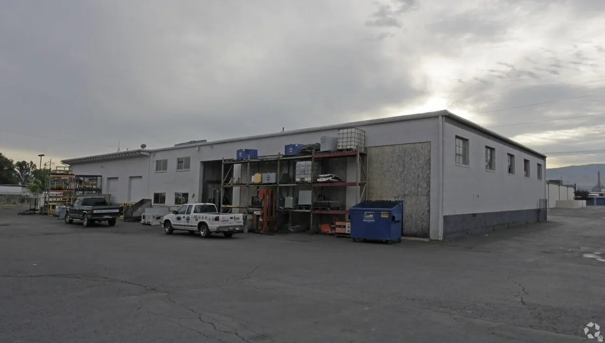 Commercial building with multiple roll-up doors and a large paved parking area