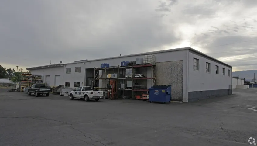 Commercial building with multiple roll-up doors and a large paved parking area