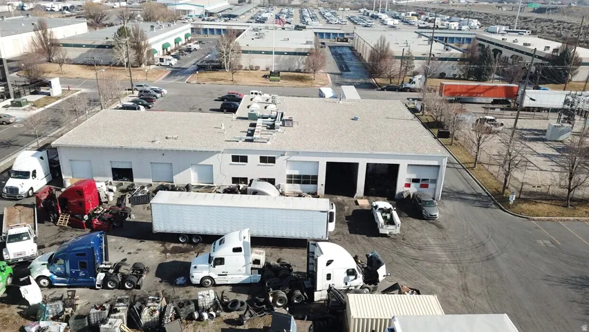 Industrial building featuring multiple bay doors and a surrounding paved lot