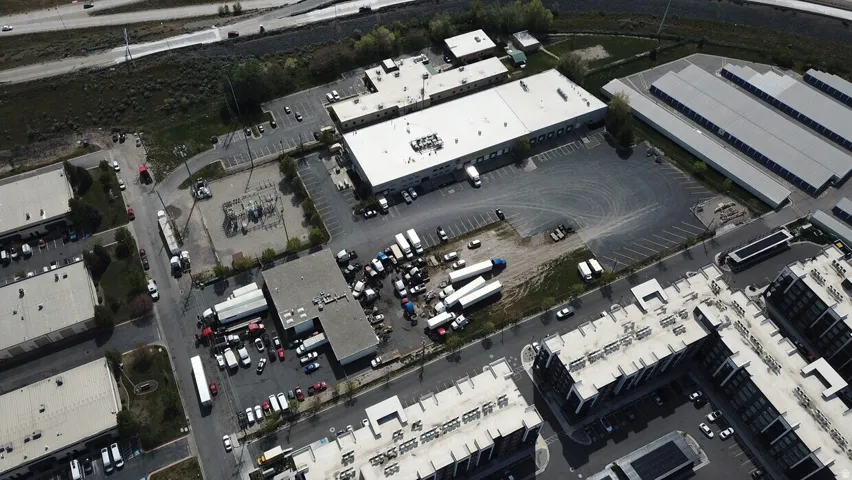 Extensive industrial property featuring multiple buildings, expansive asphalt parking areas, and loading docks