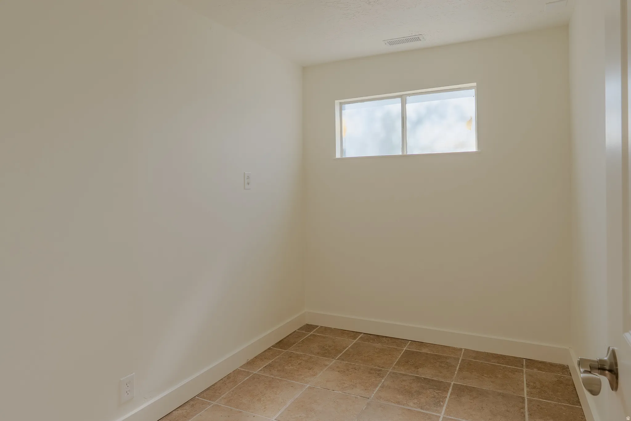 Room featuring neutral walls, tile flooring, and a single window