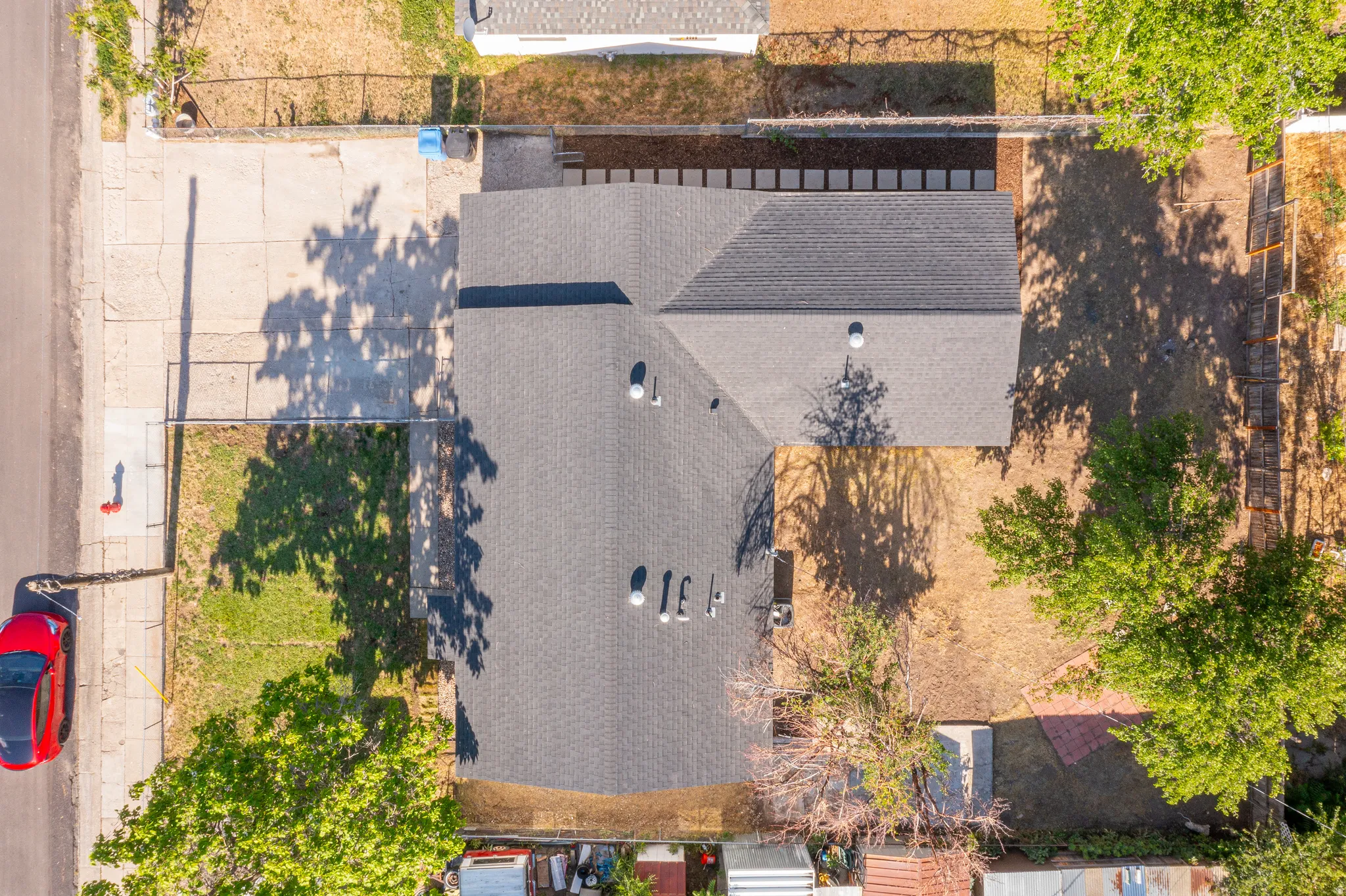 Property featuring a dark shingle roof, a concrete driveway, and an adjacent grassy area