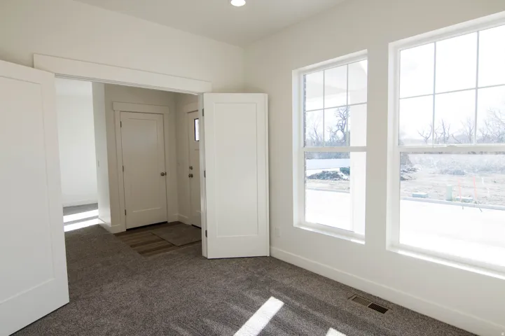 Room featuring neutral gray carpeting and multiple windows