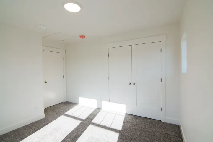 Neutral-toned room featuring a double-door closet with polished chrome hardware