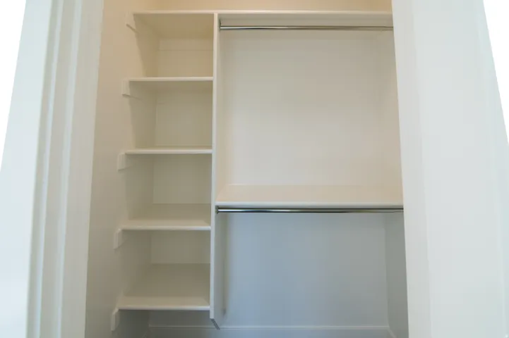 White closet system featuring five shelving units and two chrome hanging rods