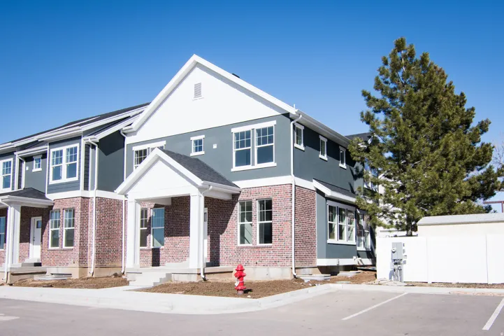 Multi-level residential exterior featuring brick and gray siding