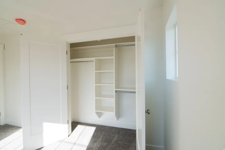 White closet system featuring multiple shelves and hanging rods