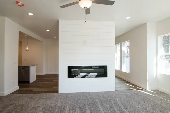 Living area featuring a modern fireplace with a linear insert, shiplap accent wall, and recessed lighting