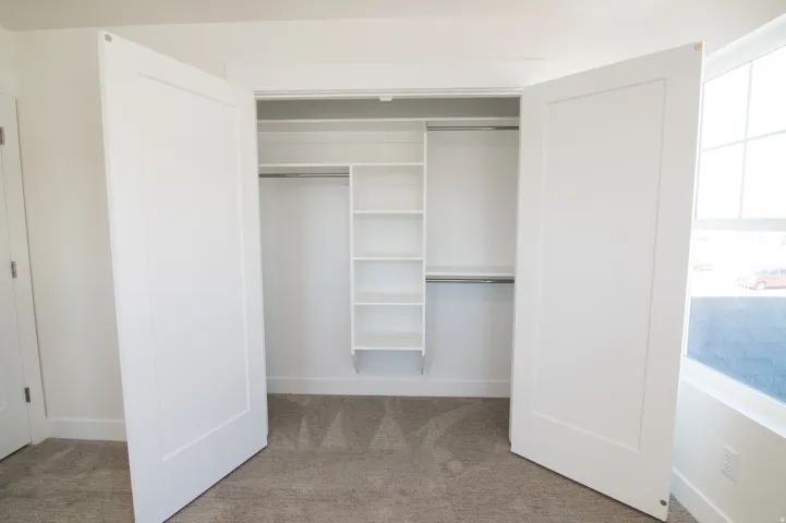 Functional closet featuring custom shelving and hanging rods