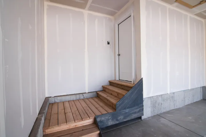 Garage interior featuring a concrete floor, unfinished drywall with taped seams, and a concrete foundation wall