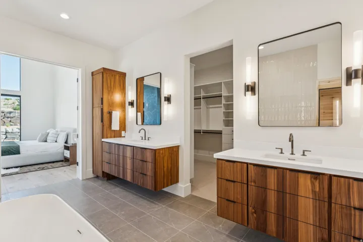 Dual floating wood-finish vanities with rectangular sinks and white countertops