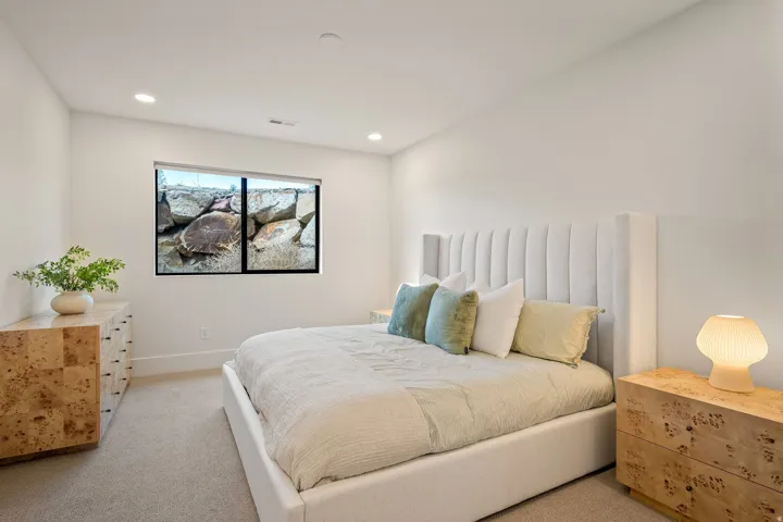 Bedroom featuring neutral wall colors, recessed ceiling lighting, a large window with black trim, and carpeted flooring